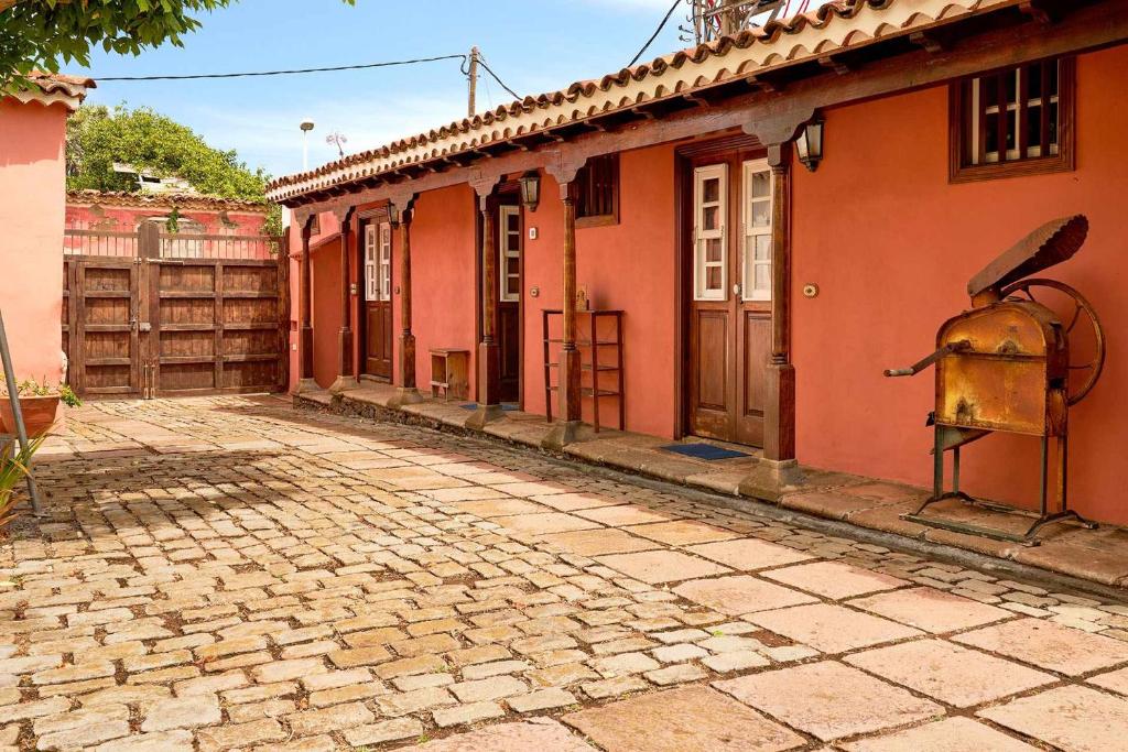una strada vuota accanto a un edificio rosso di Finca Arce Live Canarias a Tacoronte