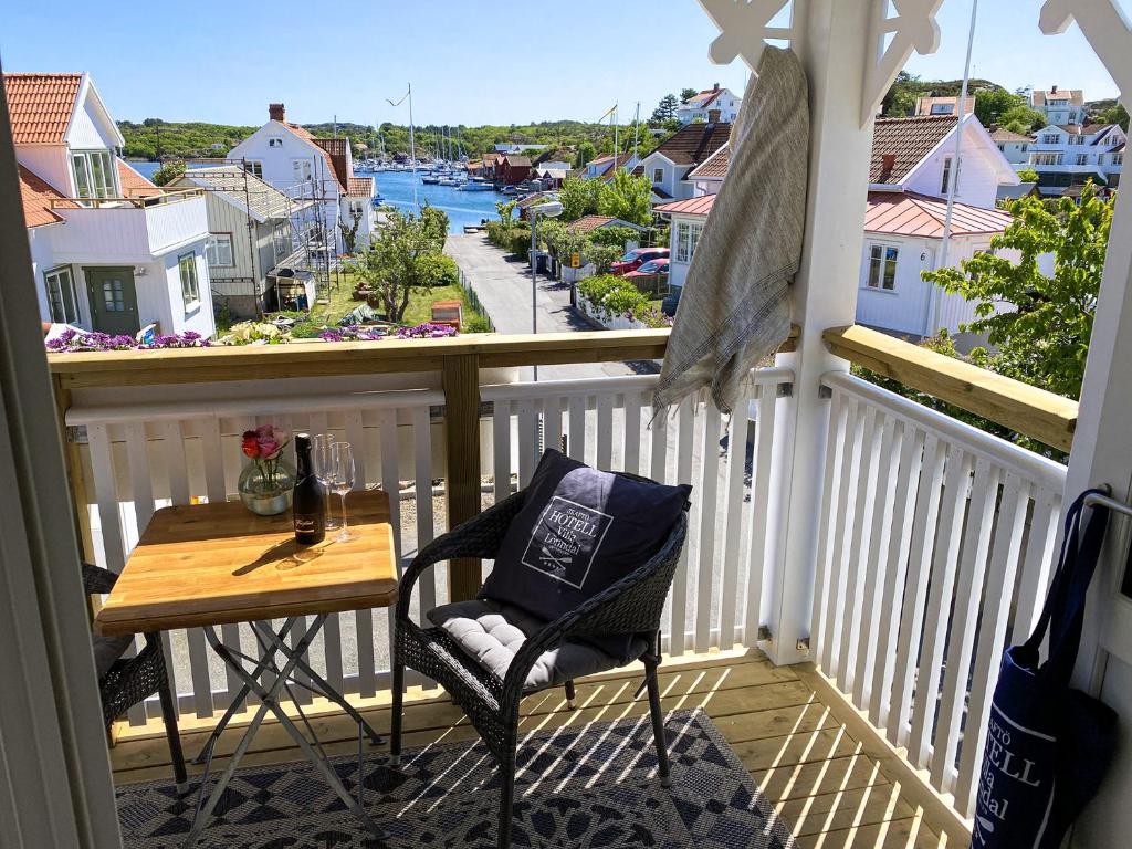 una mesa y una silla en un balcón con vistas en Skaftö Hotell Villa Lönndal, Grundsund en Grundsund