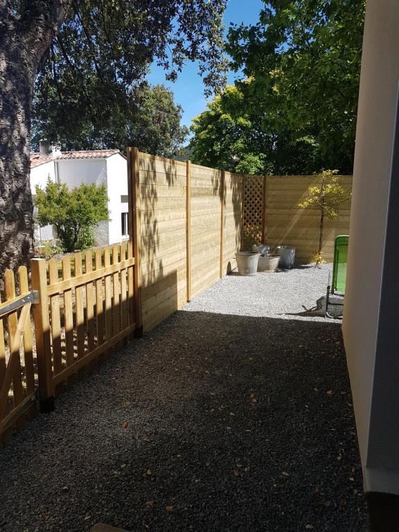 a wooden fence with a gate in a yard at Au ptit Manoir in Montbert