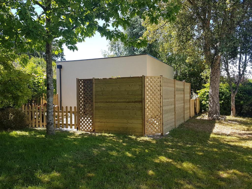 a building with a wooden garage in a yard at Au ptit Manoir in Montbert