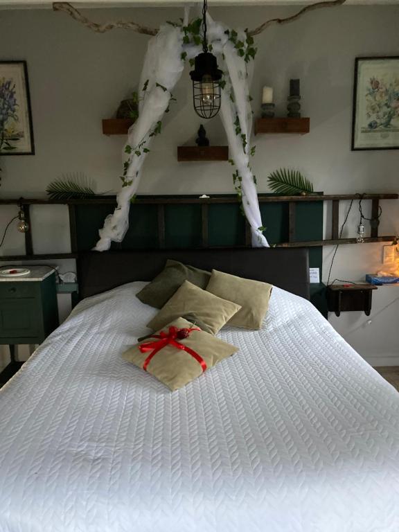 ein weißes Bett mit einem Bogen darüber in der Unterkunft L'intimité de l'Ô in Merbes-le-Château