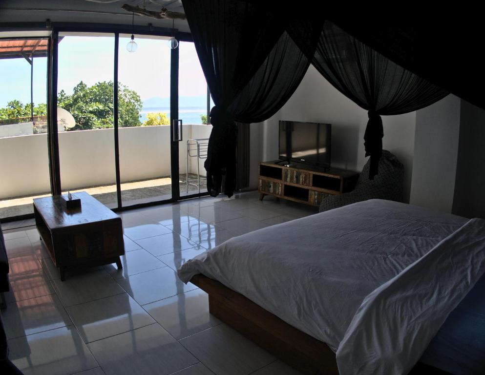 a bedroom with a bed and a view of a balcony at 3 Waves Hotel in Huu
