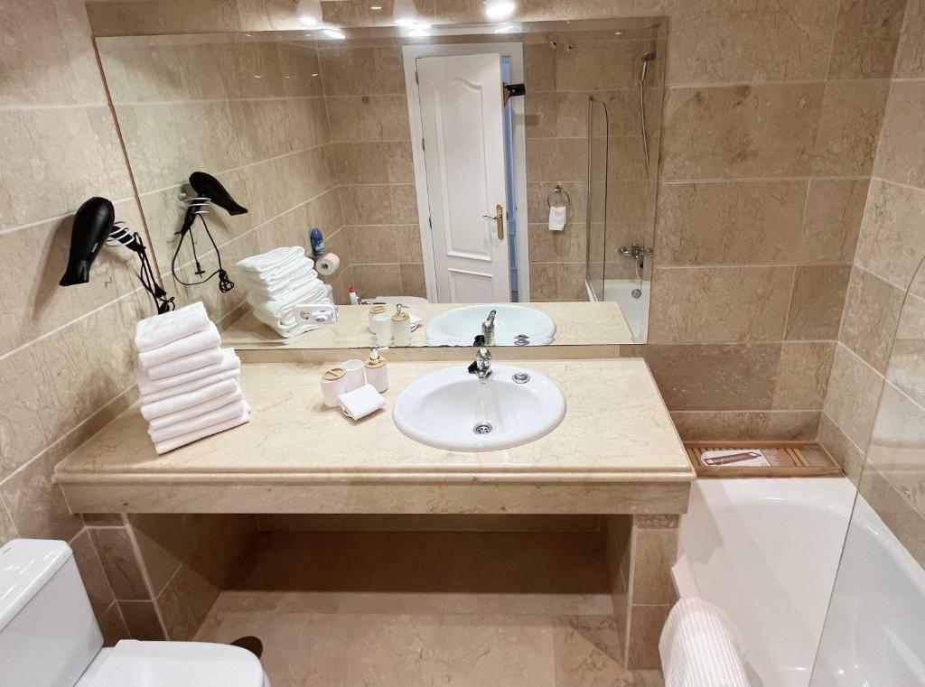 a bathroom with a sink and a toilet and a mirror at Boutique apartment 365 - Marbella in Marbella