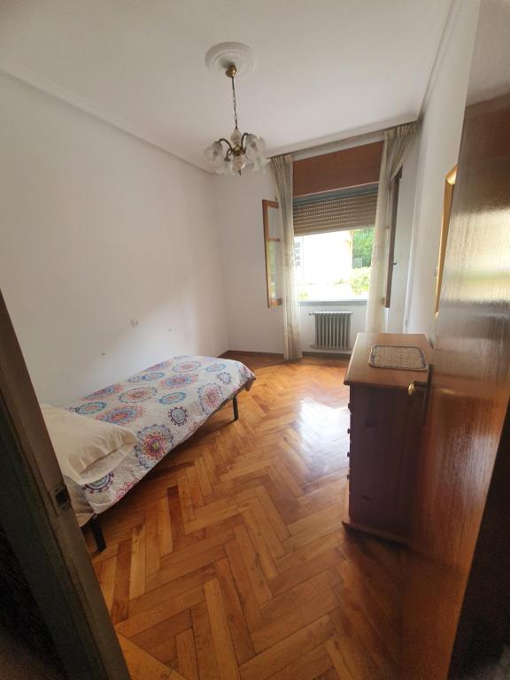 a small bedroom with a bed and a wooden floor at La Llave 