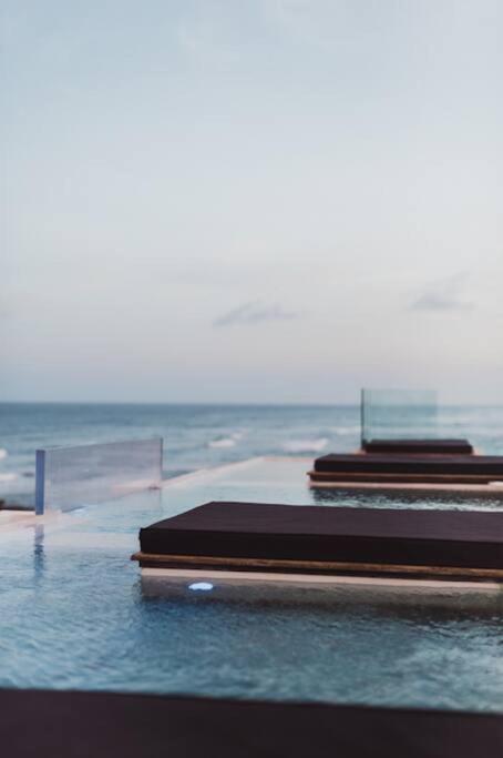 three beds on a table with the ocean in the background at TULUM Beachfront Villa I'Ik by Casa Xuul Tulum in Tulum
