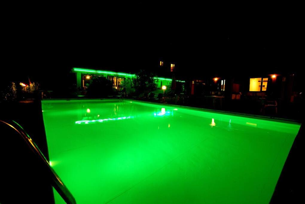 einen Pool mit grüner Beleuchtung in der Nacht in der Unterkunft Villa (apartment F) — Pool — Lake Idro in Vesta