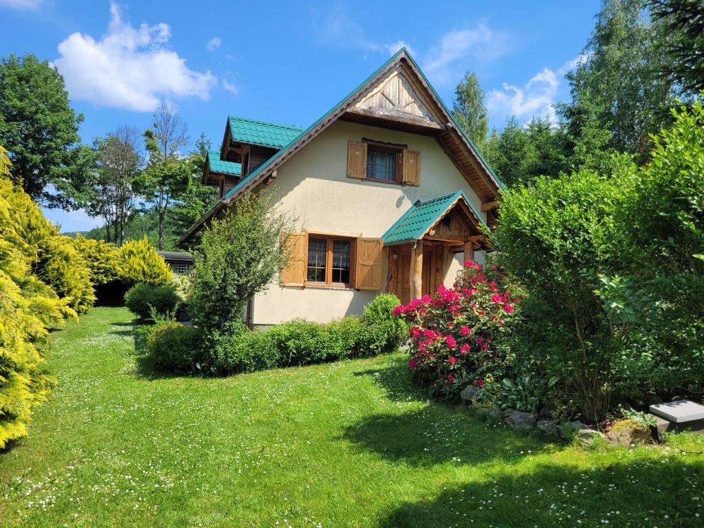 una casa con un patio con flores en Dom w Górach Sowich Niedźwiedzia Gawra, Michałkowa, en Michałkowa