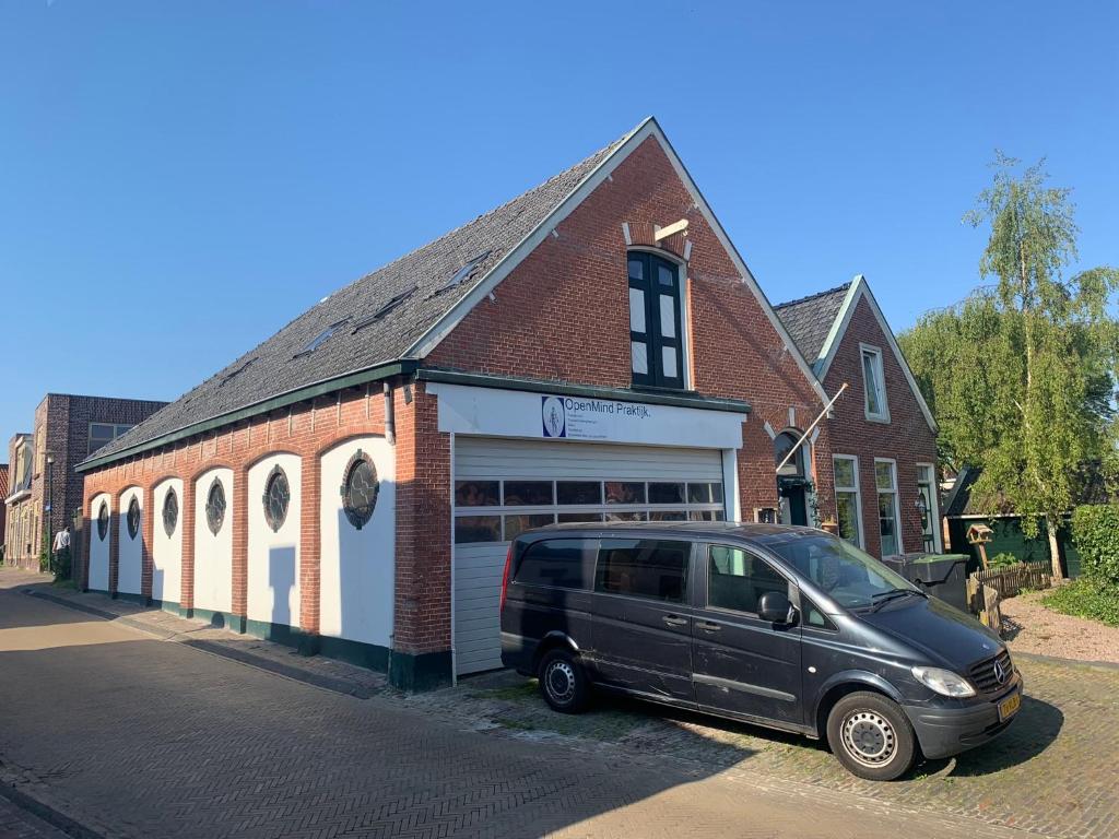 a van parked in front of a brick building at De oude paardentramremise in Ulrum