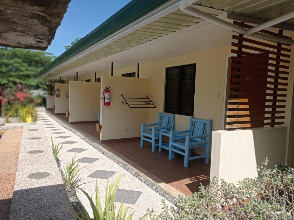 a patio with blue chairs on a house at Midnite Inn in Panglao