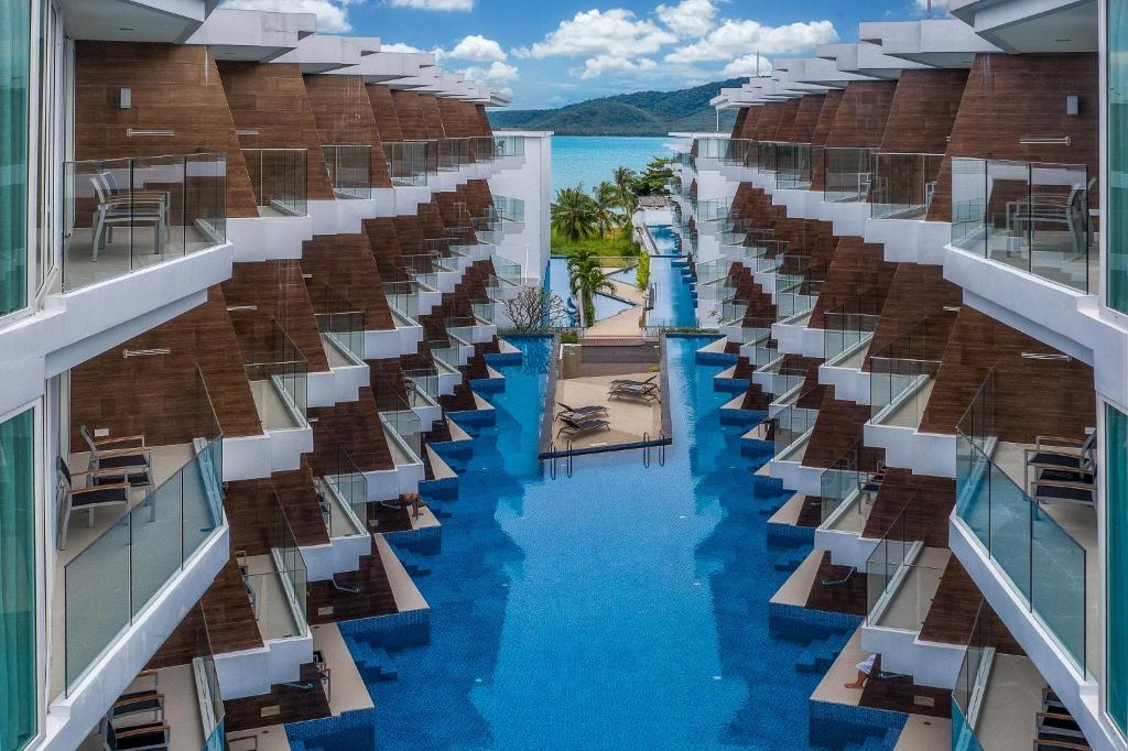 - une vue depuis le balcon d'un hôtel avec piscine dans l'établissement The Beachfront Hotel Phuket, à Rawai Beach