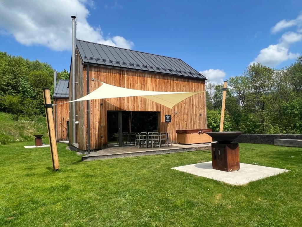 a large wooden barn with a table and chairs at 4 DOMY in Dolní Morava