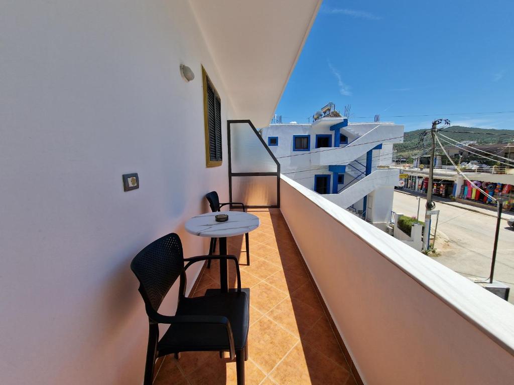 a balcony with a small table and chairs on a building at Villa White in Ksamil