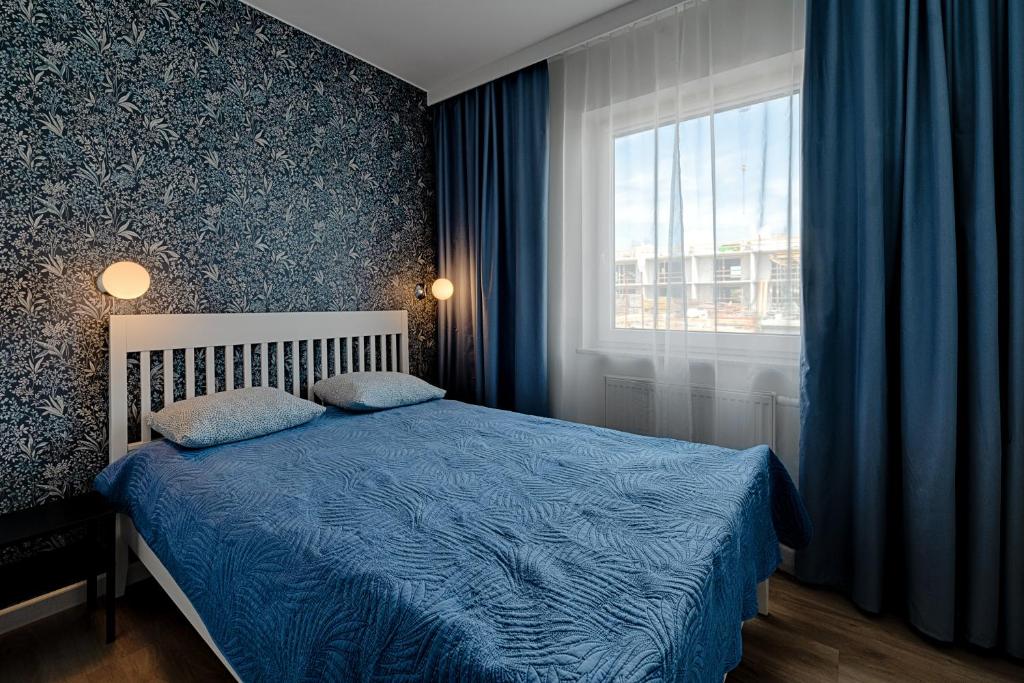 Un dormitorio con una cama azul y una ventana en Apartamenty MM - Rzeźniczaka, en Zielona Góra