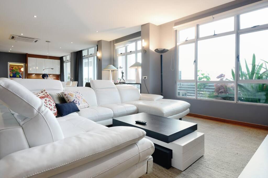 sala de estar con sofá blanco y mesa en Lavish Retreat: Stylish & Scenic Penthouse, en Johor Bahru