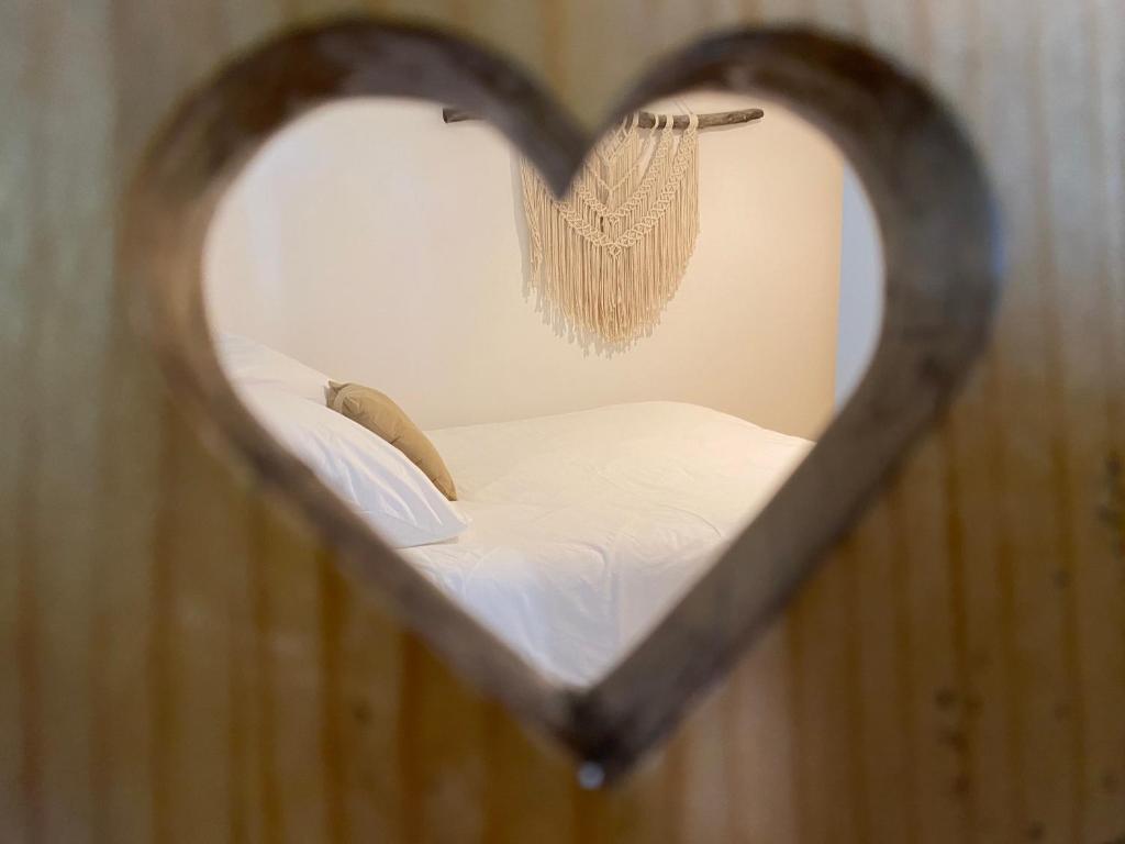 - un miroir en forme de cœur avec un lit dans une chambre dans l'établissement Les Sources, à Fontaine-de-Vaucluse