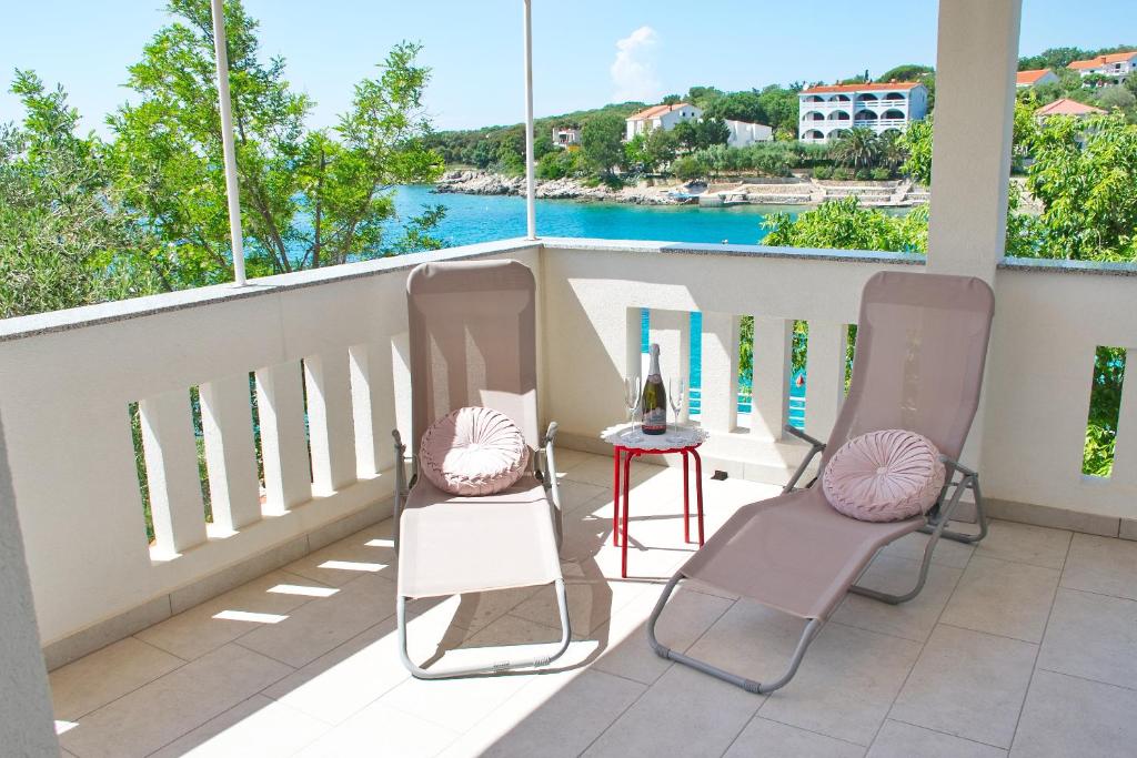 two chairs and a table on a balcony with a view of the water at SeaSide VARSAN in Borovići