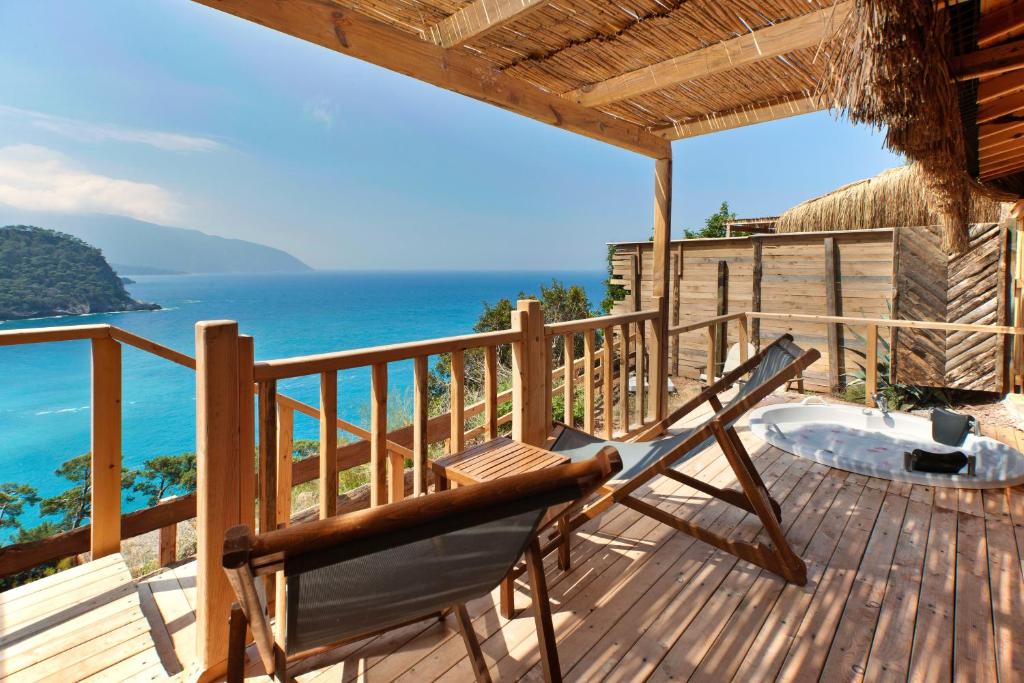a chair on a deck with the view of the ocean at Flavia Hotel in Kızılcakaya