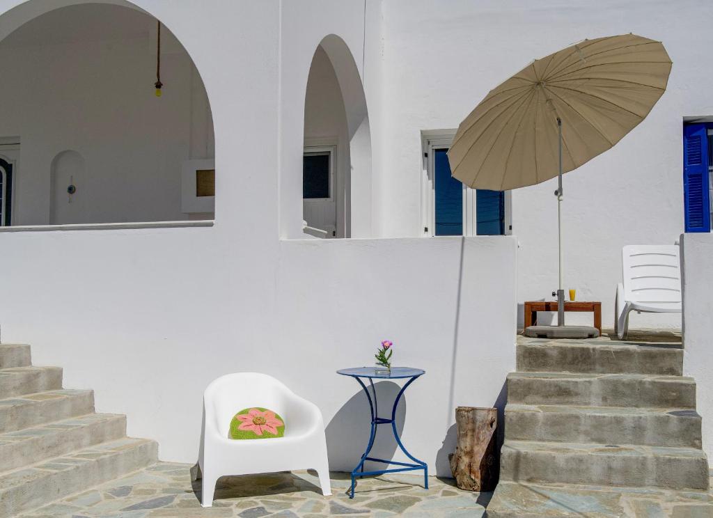 a white room with a chair and an umbrella at Eva House Dryos Beach Paros in Drios