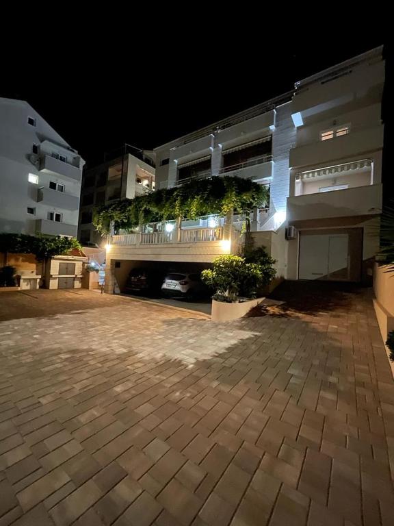 a parking lot in front of a building at night at Apartments Stone Tučepi in Tučepi