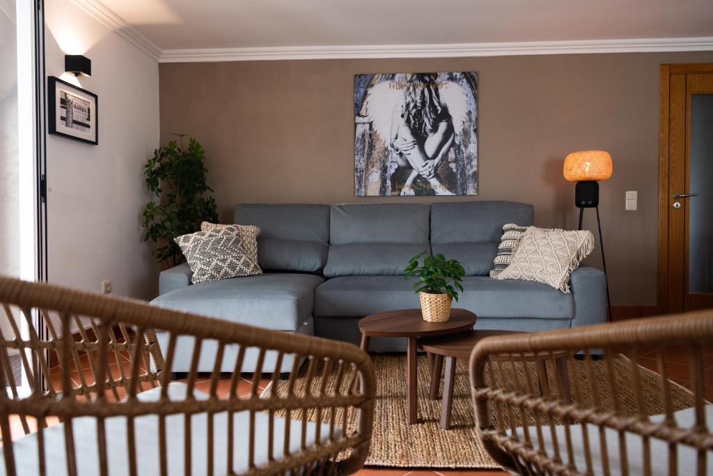 a living room with a blue couch and a table at Casa La Rosa with private pool in Loja de Vendas