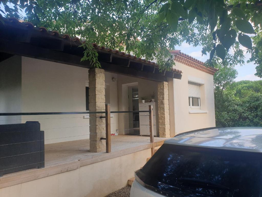 uma casa com um alpendre e um carro estacionado em frente em Villa calme em Uchaud