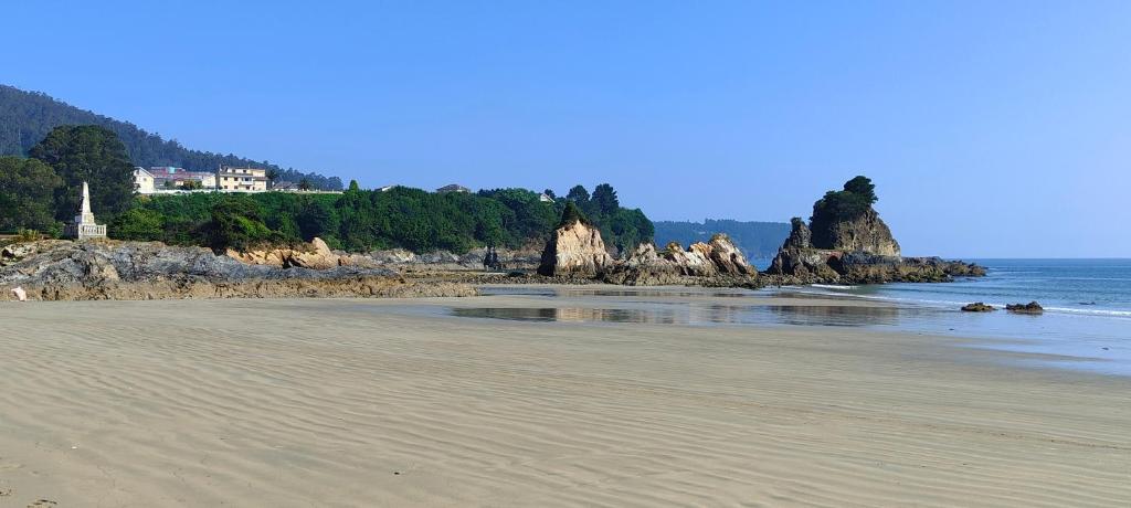 vistas a una playa con una casa en la orilla en Alojamientos Viveiro - Playa de Covas II en Viveiro