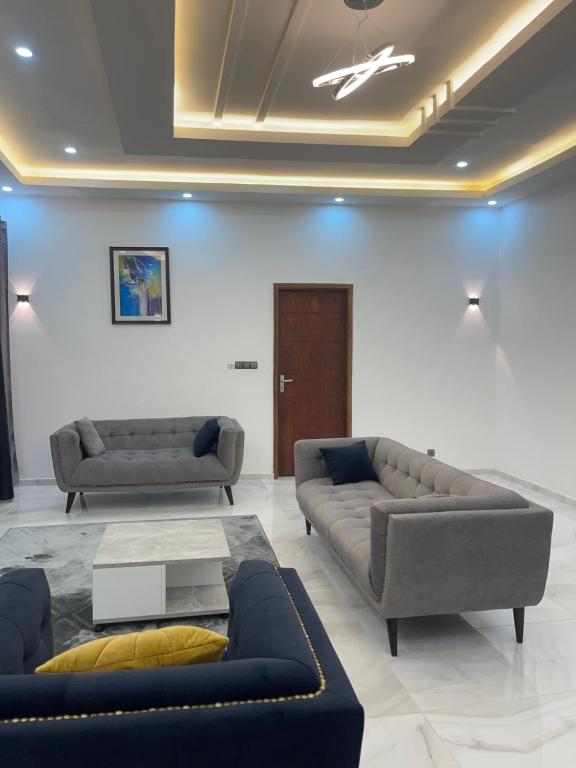 Sala de estar con 2 sofás y mesa en Appartement Kekely en Lomé