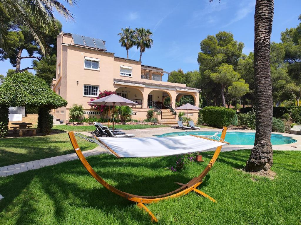 a hammock on the grass in front of a house at Casa Cosy in Serra