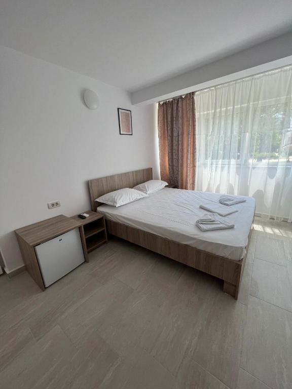 a bedroom with a large bed and a window at Complex Marea Neagra in Eforie Nord