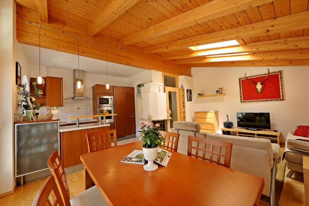 een keuken en woonkamer met een houten tafel en stoelen bij Alpen Appartements MOIGG in Mayrhofen