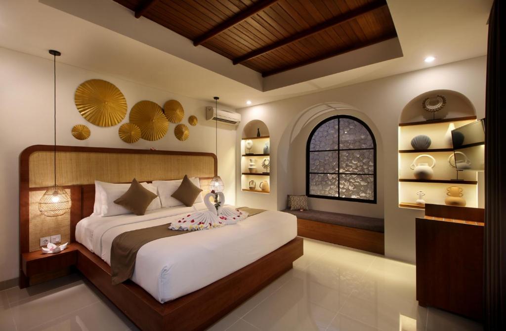 een slaapkamer met een groot bed en een raam bij Sudha Villa Bali Anyelir in Seminyak