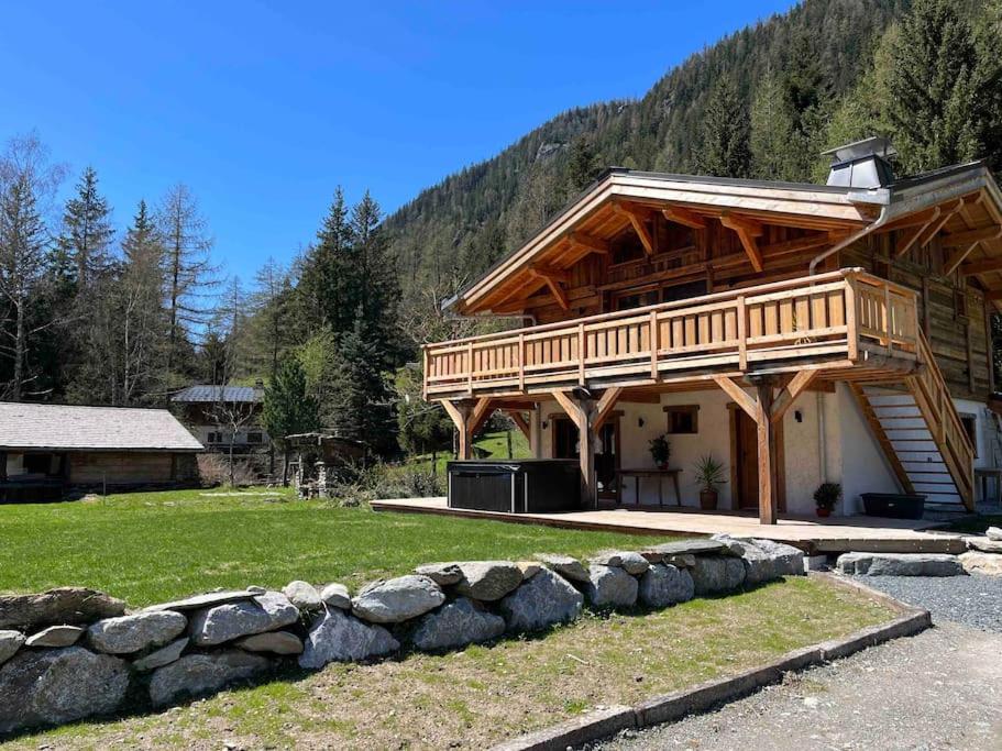 uma grande cabana de madeira com uma parede de pedra em frente em Chalet Le petit paradis - Chamonix-Mont-Blanc em Chamonix-Mont-Blanc