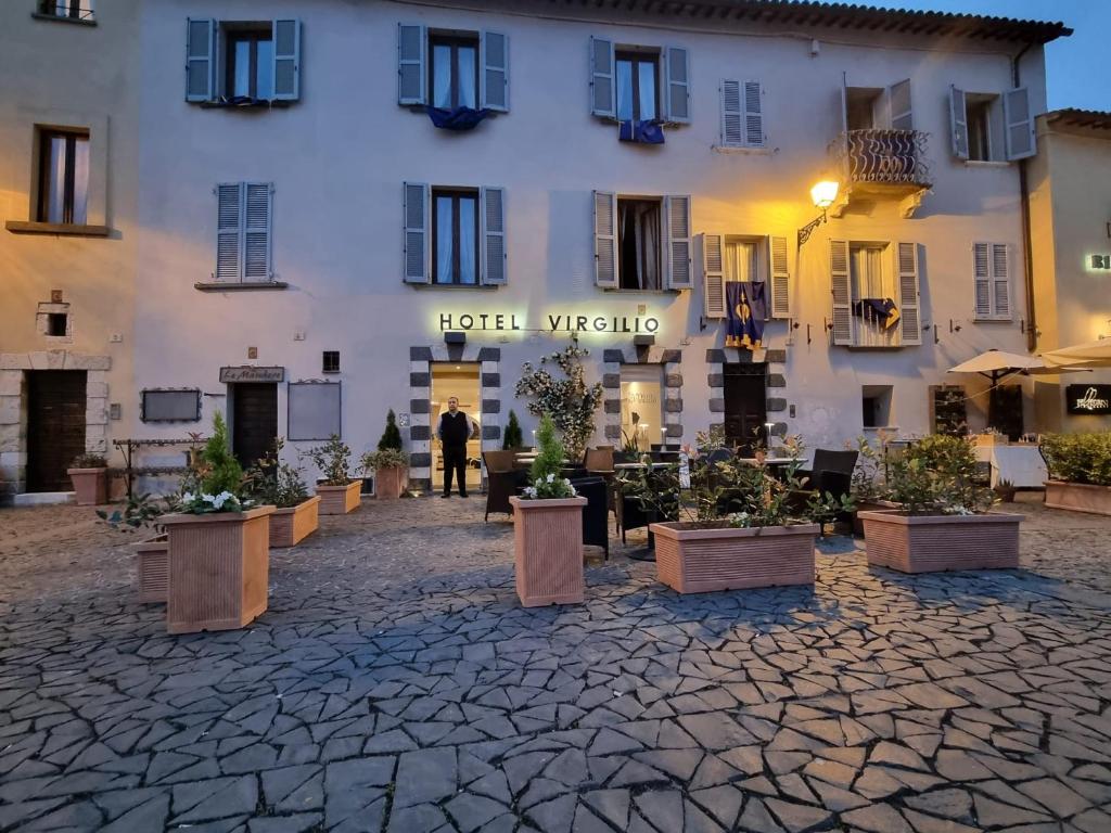 a hotel with potted plants in front of a building at Hotel Virgilio in Orvieto