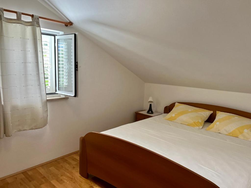 コルチュラにあるApartmani Lukaのベッドルーム(ベッド1台、窓付)