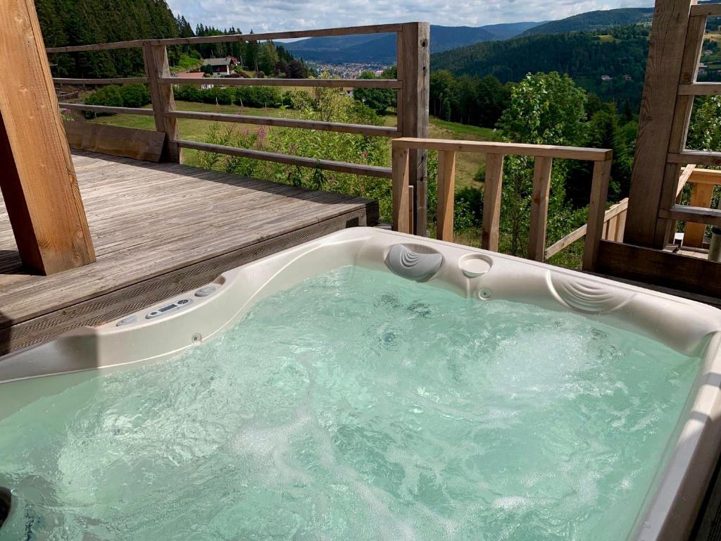 une baignoire jacuzzi sur une terrasse avec vue dans l'établissement LES BALCONS DU PHENY LE REFUGE, à Gérardmer