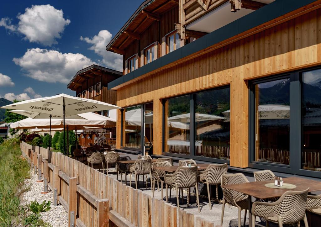 un restaurante al aire libre con mesas, sillas y sombrillas en Ferienalm Panorama Hotel, en Schladming