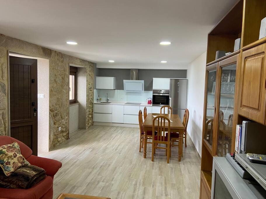 a kitchen and dining room with a table and chairs at J. Casa con vistas en Lira - Carnota in Lira