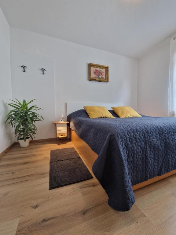um quarto com uma cama e um vaso de plantas em Medeni Apartma em Pivka