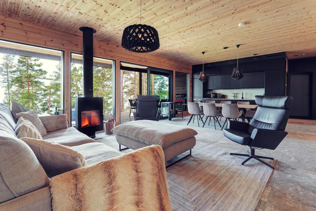 a living room with a couch and a fireplace at Saunamäki Resort - Lux Villa in Salo