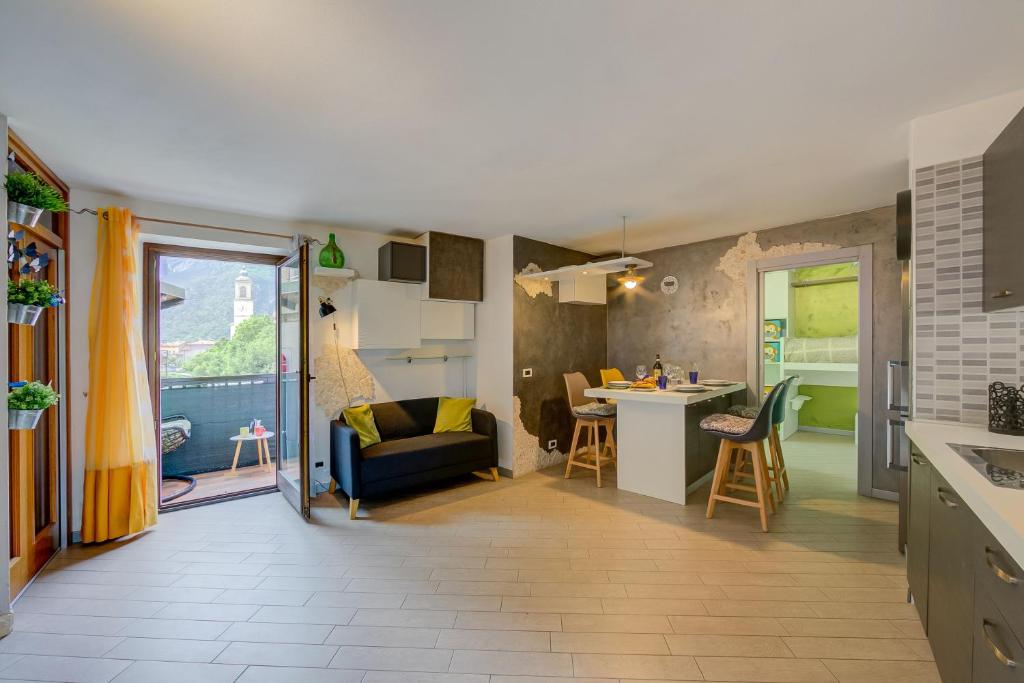 een keuken en een woonkamer met een bank en een tafel bij Casa Gio Few Minutes from the Lake - Happy Rentals in Riva del Garda