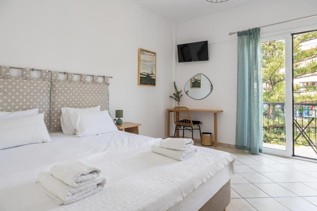 a bedroom with a large white bed with towels on it at Annis House in Skiathos Town