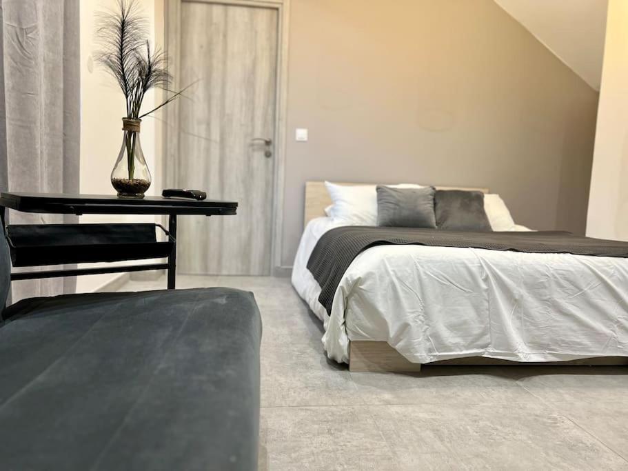 una camera da letto con un letto e un tavolo con un vaso sopra di Studio Charmant Proche RER CDG Parc des expos a Sevran