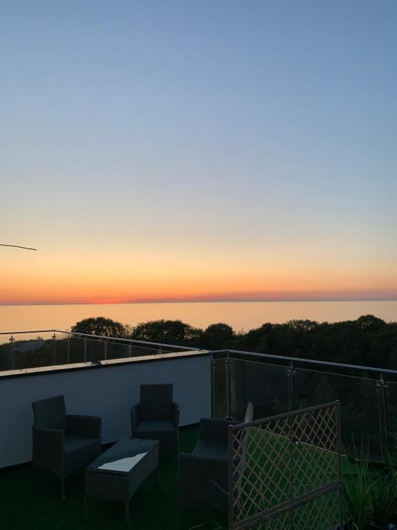 a view of the sunset from the balcony of a house at Apartamenty Piaskowe Wypoczynkowa 3 in Rowy