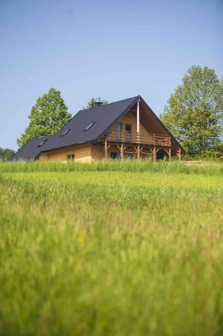 a large wooden house in a field of grass at Chata Buena Vista in Wawrzka