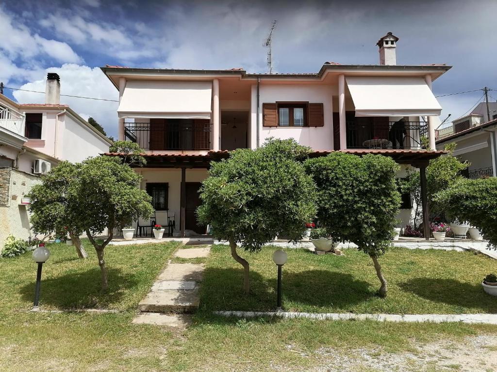 a house with trees in front of it at Porto Almira Beachfront Apartrments in Nikiti