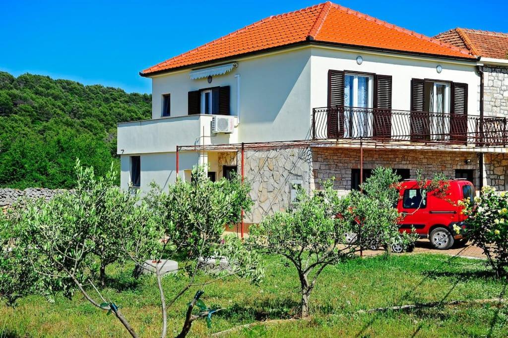 un camión rojo estacionado frente a una casa en Apartman Marin-Dalmatian way of vacation, en Gornje Selo