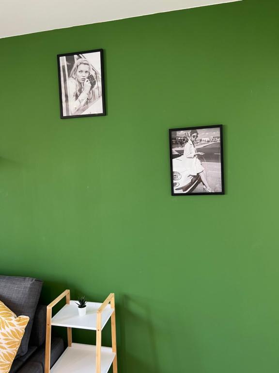 a living room with two pictures on a green wall at Contemporary Haven in Châtenay-Malabry