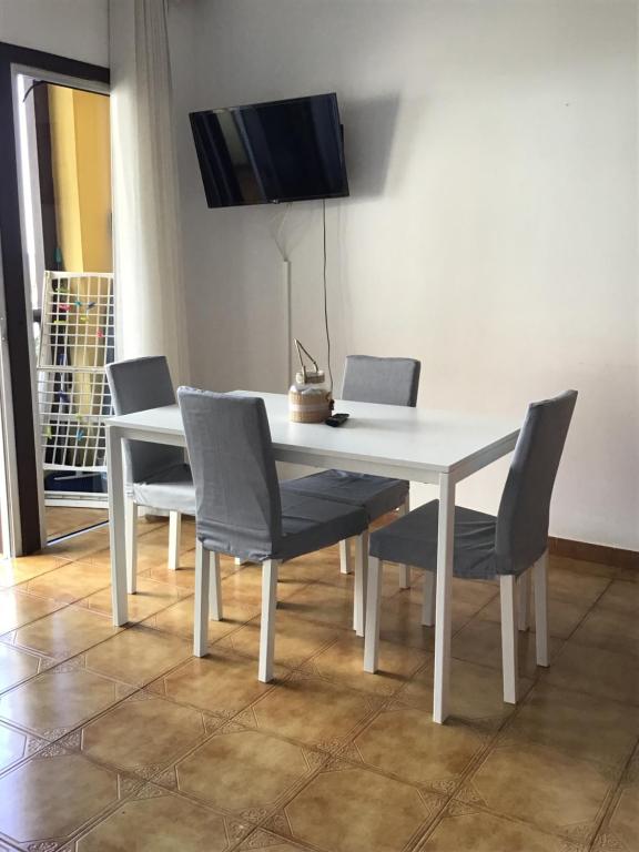 a white dining room table with chairs and a tv at Apartamentos Playamar in La Playa Calera