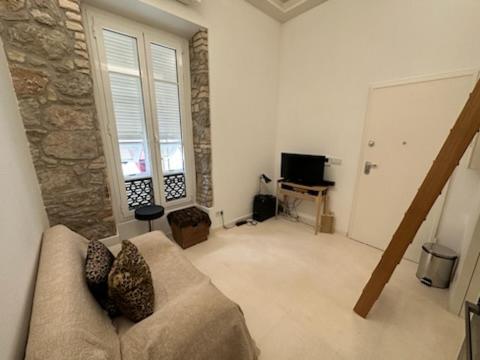uma sala de estar com um sofá e uma parede de pedra em Studio port hercule Monaco em Monte Carlo