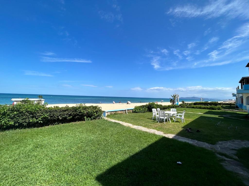 弗尼迪克的住宿－Magnifique Villa Front de Mer à Fnideq，海滩上带椅子的草坪和灯塔